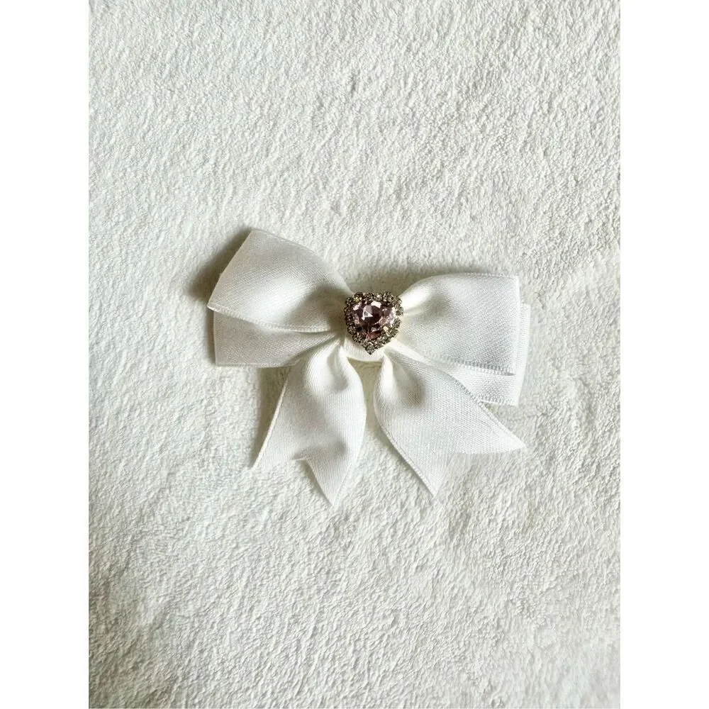 White bow hair clip with pink rhinestone heart ￼